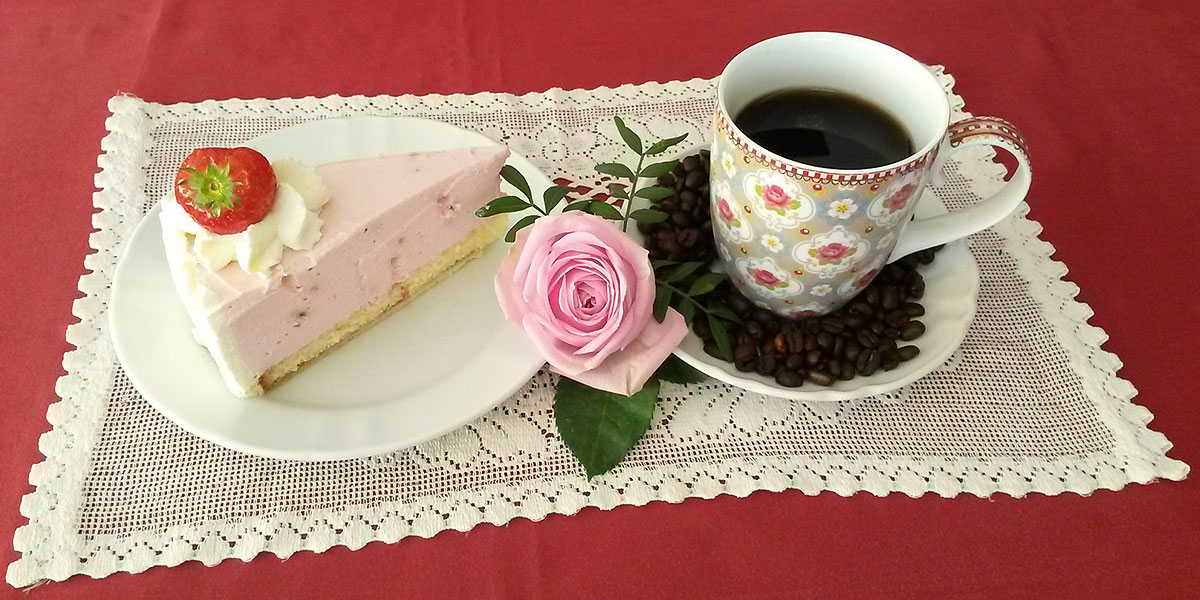 Ein Café Gedeck mit Torte und Kaffee